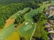 Aerial view of the golf course and surrounding neighborhood featuring lush trees and manicured lawns at 108 Ribbon Walk Ln, Holly Springs, NC 27540