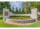 Welcoming community entrance with brick pillars, stone accents, and manicured landscaping enhancing curb appeal at 108 Ribbon Walk Ln, Holly Springs, NC 27540