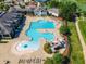 Aerial view of a Gathering friendly pool area with slides, lounge chairs, and umbrellas at 108 Ribbon Walk Ln, Holly Springs, NC 27540