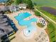Stunning aerial shot of the neighborhood pool with slides and plenty of lounge chairs at 108 Ribbon Walk Ln, Holly Springs, NC 27540
