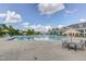 Beautiful community pool area with water slide, lounge chairs, umbrellas, and clear blue skies at 108 Ribbon Walk Ln, Holly Springs, NC 27540