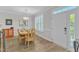 Bright dining room with a wooden table, decorative light fixture, and a view of the front door at 108 Ribbon Walk Ln, Holly Springs, NC 27540