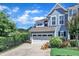 Charming home featuring a two-car garage and a well-manicured lawn, under a partly cloudy, bright blue sky at 108 Ribbon Walk Ln, Holly Springs, NC 27540
