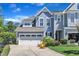 Charming two-story home featuring a two-car garage, a well-manicured lawn, and two chairs on the front porch at 108 Ribbon Walk Ln, Holly Springs, NC 27540