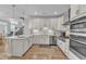 Modern kitchen with white cabinets, stainless steel appliances, and a quartz countertop at 108 Ribbon Walk Ln, Holly Springs, NC 27540