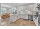 Bright eat-in kitchen with white cabinets, stainless steel appliances and hardwood floors at 108 Ribbon Walk Ln, Holly Springs, NC 27540