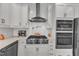 Stainless steel appliances, custom range hood and white cabinets offer a clean, modern design at 108 Ribbon Walk Ln, Holly Springs, NC 27540