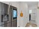 Modern stainless steel refrigerator with screen display adjacent to laundry room at 108 Ribbon Walk Ln, Holly Springs, NC 27540