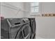 Modern laundry room with front load washer and dryer at 108 Ribbon Walk Ln, Holly Springs, NC 27540