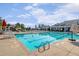 Large outdoor pool with lap lanes, a slide, lounge chairs, and umbrellas on a sunny day at 108 Ribbon Walk Ln, Holly Springs, NC 27540