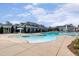 Stunning pool area with a shallow entry, lap lanes, umbrellas, and a clubhouse in the background at 108 Ribbon Walk Ln, Holly Springs, NC 27540