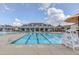 Large community swimming pool with umbrellas, lounge chairs, and lifeguard station for resident's enjoyment at 108 Ribbon Walk Ln, Holly Springs, NC 27540