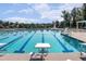 Beautiful community swimming pool featuring lap lanes, diving boards, and a lifeguard stand on a partly cloudy day at 108 Ribbon Walk Ln, Holly Springs, NC 27540