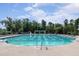 Community swimming pool featuring lap lanes, ladders, and lounge chairs under a partly cloudy sky at 108 Ribbon Walk Ln, Holly Springs, NC 27540