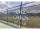 Well-maintained tennis court at 12 Oaks The Club, surrounded by fencing and scenic greenery at 108 Ribbon Walk Ln, Holly Springs, NC 27540