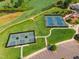 Aerial view of community tennis and pickleball courts, parking, and golf course at 108 Ribbon Walk Ln, Holly Springs, NC 27540