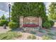 Stone welcome sign to The 12 Oaks Club with flower bed and manicured landscaping at 108 Ribbon Walk Ln, Holly Springs, NC 27540