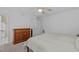 Neutral bedroom with a wooden dresser, fan, and adjacent bathroom at 112 Barcelona Ct, Cary, NC 27513