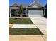Charming home featuring a covered porch, two-car garage, and freshly laid sod at 144 N Keatts Winner Ct, Wilson's Mills, NC 27520
