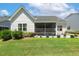 Exterior view of a home with a screened-in porch and patio adorned with lush greenery and colorful flower pots at 149 Ivory Ln, Raleigh, NC 27610