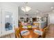 Bright dining area with wood table, stylish light fixture, and a view into the open-concept living area at 149 Ivory Ln, Raleigh, NC 27610