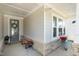 Cozy covered porch with stone accents, a bench, and decorative plants at 149 Ivory Ln, Raleigh, NC 27610