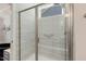 Modern walk-in shower with glass door, bench seat, and tiled walls at 149 Ivory Ln, Raleigh, NC 27610