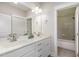 Bright bathroom features double sinks, white cabinetry, and a tile-surround tub and shower combo at 150 Luxorwind Dr, Garner, NC 27529