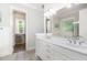 Bright bathroom featuring a double vanity, white cabinets, and a large mirror at 150 Luxorwind Dr, Garner, NC 27529