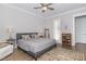 This bedroom offers a ceiling fan, gray bed, and a view into the bathroom at 150 Luxorwind Dr, Garner, NC 27529