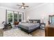 Bright bedroom featuring a ceiling fan, windows, hardwood floors, and exercise equipment at 150 Luxorwind Dr, Garner, NC 27529