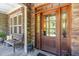 Inviting front porch with stone accents, a wooden bench, and a beautifully crafted front door at 150 Luxorwind Dr, Garner, NC 27529