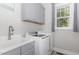 Convenient laundry room with gray cabinetry, sink, and front-loading washer and dryer at 150 Luxorwind Dr, Garner, NC 27529
