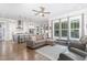 Open-concept living room with hardwood floors, large windows, and a view into the modern kitchen at 150 Luxorwind Dr, Garner, NC 27529