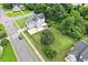 Aerial view of a light blue home with a yard, basketball court, and mature trees at 1505 Mclaurin Ln, Fuquay Varina, NC 27526