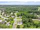Aerial view shows multiple homes in a neighborhood surrounded by mature trees and community amenities at 1505 Mclaurin Ln, Fuquay Varina, NC 27526