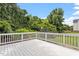 White, open back deck overlooking a lush green lawn and treelined fence at 1505 Mclaurin Ln, Fuquay Varina, NC 27526