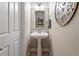 Cozy powder room featuring pedestal sink, decorative mirror and stylish decor at 1505 Mclaurin Ln, Fuquay Varina, NC 27526