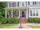 Inviting front porch with rocking chairs, decorative plants, and classic architectural columns at 1505 Mclaurin Ln, Fuquay Varina, NC 27526