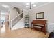 Spacious living room with hardwood floors, a piano, a staircase and ample natural light at 1505 Mclaurin Ln, Fuquay Varina, NC 27526
