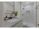 Modern bathroom with a granite countertop, sleek vanity, and a glass-enclosed shower with tiled walls at 1709 Hawthorne Lane Ln, Burlington, NC 27215