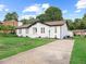 Exterior view of a charming home with well-kept lawn, driveway, and inviting curb appeal at 1709 Hawthorne Lane Ln, Burlington, NC 27215