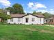 Charming renovated one-story home featuring a well-manicured front yard and a classic white exterior at 1709 Hawthorne Lane Ln, Burlington, NC 27215