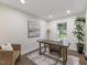 Bright office space features a modern desk, comfortable seating, stylish rug, and natural light from the window at 1709 Hawthorne Lane Ln, Burlington, NC 27215