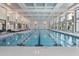 Indoor swimming pool area with lounge chairs and floor to ceiling windows at 173 Churchill Way, Clayton, NC 27520