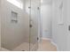 This walk-in shower features tiled walls, a shower niche, and a glass door at 173 Churchill Way, Clayton, NC 27520