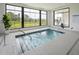 Indoor hot tub with tile surround and view of the fenced backyard from a large window at 173 Churchill Way, Clayton, NC 27520
