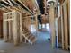 Wooden staircase in an unfinished home with exposed beams and door to the outside at 1808 Falls Landing Dr, Raleigh, NC 27614