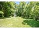 Spacious backyard featuring mature trees, green grass and storage shed at 200 W Corbin St, Hillsborough, NC 27278