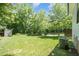 Expansive backyard featuring mature trees, green grass and storage shed at 200 W Corbin St, Hillsborough, NC 27278